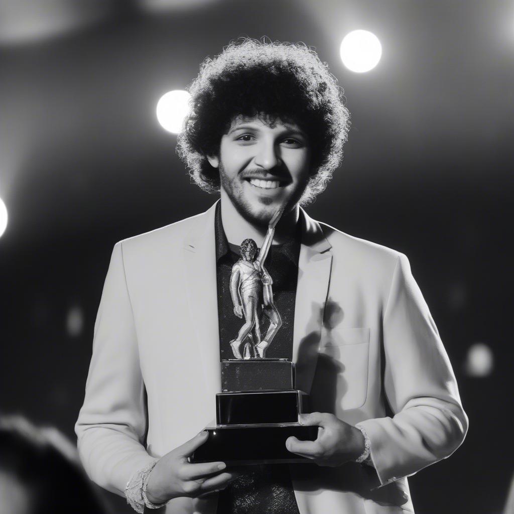 Benny Blanco accepting a music award on stage.