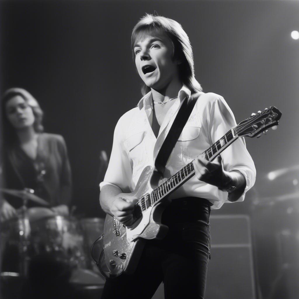 David Cassidy performing "Rock Me Baby" on stage, exuding energy and showmanship